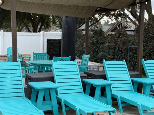 Customer's bright blue Two Tier Rectangular End Table between matching chaise lounges on a patio.