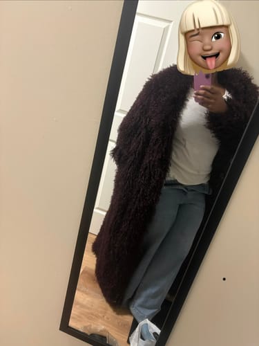 Reviewer in a mirror selfie wearing the dark, plush Faux Fur Long Coat.
