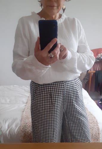 Cliente portant le pantalon Tom en flanelle de coton vichy avec une blouse blanche.