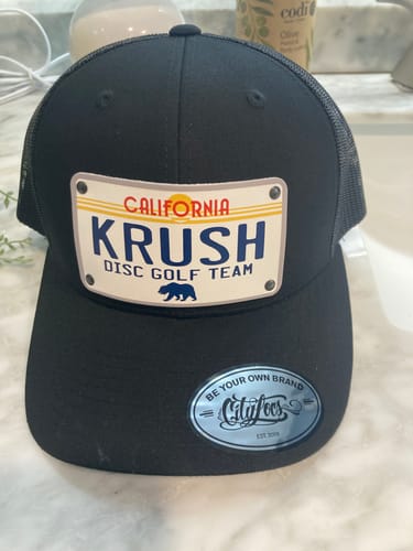 Reviewer's black trucker hat, a California Sunny Plate Hat, with a custom patch reading "KRUSH DISC GOLF TEAM".