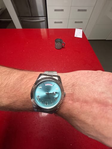 Reviewer wearing the Lucky Fours® Santos watch with a light blue dial and silver-colored band on their wrist.