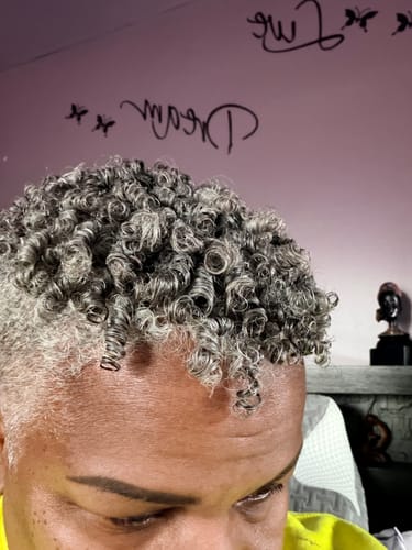 Close-up of a reviewer's shiny, defined gray curls after using the GLOSS THERMAL STYLING SERUM.