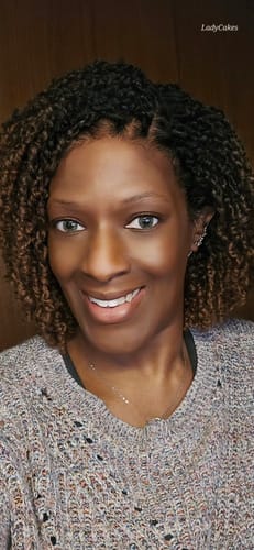Reviewer wearing the Chade Magic Lace Yanky Twist wig, styled with dark roots and brown twists.
