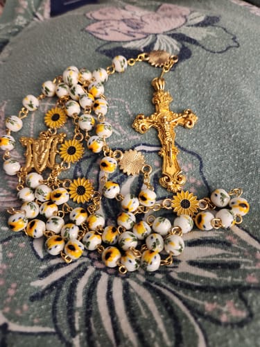Reviewer's handmade sunflower rosary, showing the gold sunflower medallions and painted floral beads.