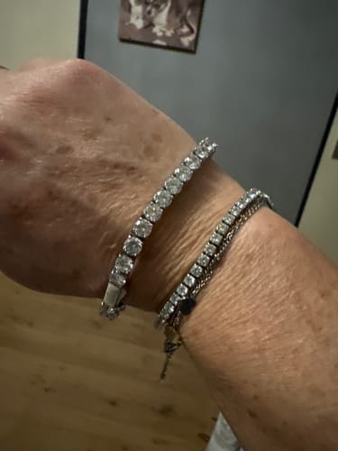 Customer wearing the shiny TENNISBOY BRACELET on their wrist next to a smaller, thinner bracelet.