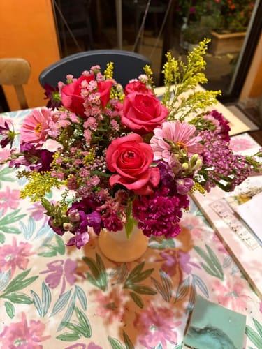 Customer's Summer Delight Posy Box, a colorful floral arrangement with pink roses in a vase on a table.