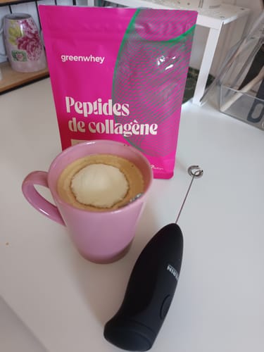Le client montre son sachet de Peptides de Collagène à côté d'une boisson préparée dans une tasse rose.