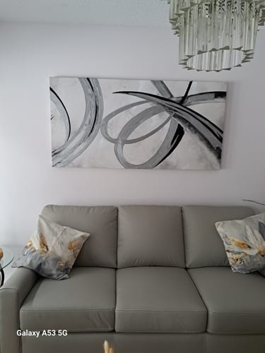 Customer's 'Winds of Change' framed canvas hanging on a wall above a gray sofa in a living room.