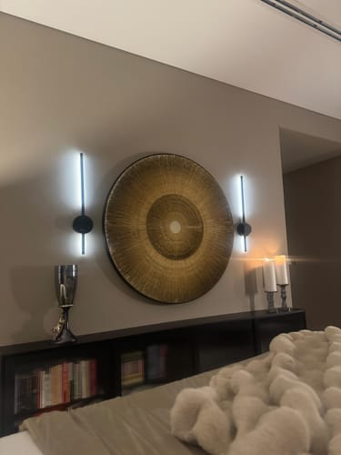 Customer's large, textured Handmade Paper Artwork hanging on a bedroom wall above a dark headboard.