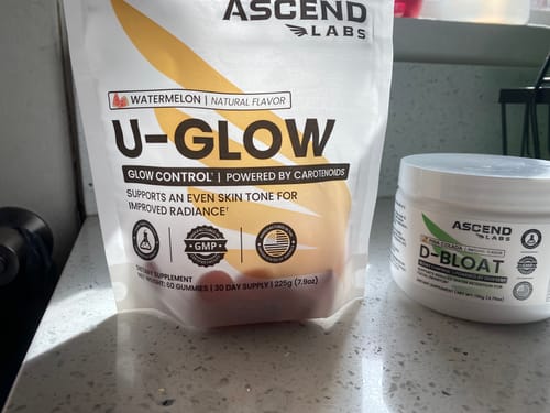 Reviewer's white D-BLOAT jar on a counter next to another Ascend Labs product.