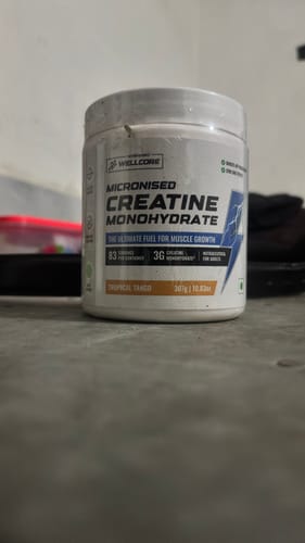 Customer's white tub of Wellcore Micronised Creatine Monohydrate sitting on a grey surface.
