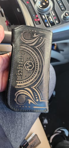 Customer holding their custom black leather Chain Wallet vertically, showing the engraved 'OMYILOTS' design.