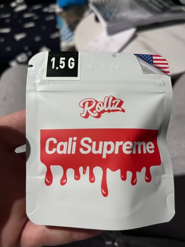 Customer holding the white and red bag of CALI SUPREME THCA Flower.