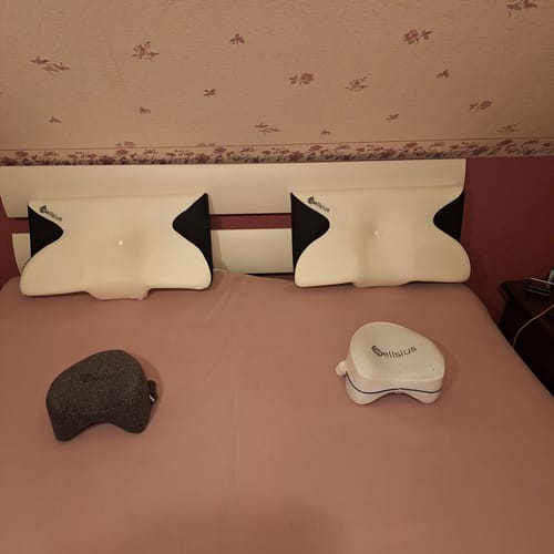 Avis d'un client montrant deux oreillers d'alignement cervical blancs et noirs sur un lit.