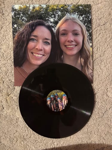 Customer's custom vinyl record with its personalized photo album cover showing two people smiling.