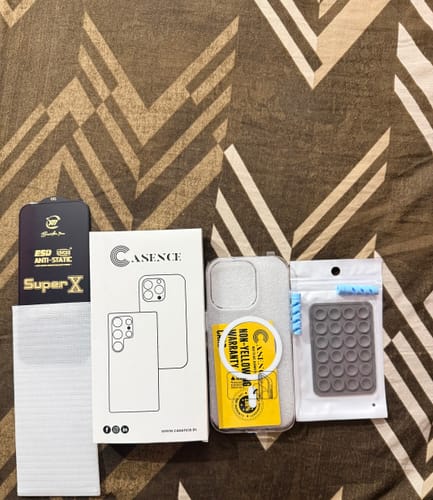 Customer's unboxed Anti Yellow Magsafe Clear Case with its packaging and accessories laid out on a patterned surface.