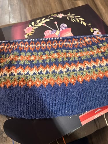 Customer's knitting project from the January Mystery Box, showing a colorful Fairisle pattern with blue as the main color.