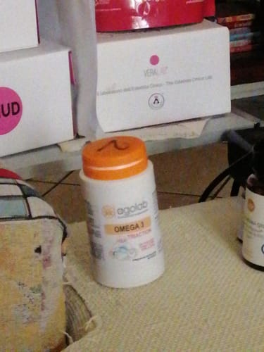 Recensione di un cliente che mostra il flacone in plastica di Omega 3 Tri-Action su un tavolo.