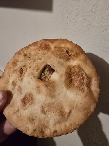 Primer plano de un cliente sosteniendo una coyota dorada con relleno de piloncillo.