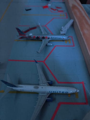 Customer's GEMINI AMERICAN A321 model airplane parked at a gate on a model airport display.