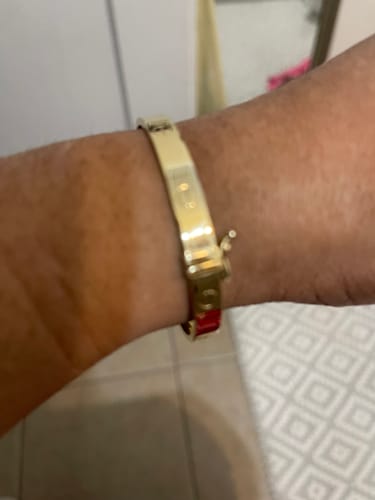 Close-up of a customer wearing the 14K Bangle Love Bracelet on their wrist, showing the clasp.
