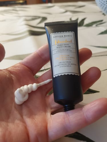 Klant houdt de zwarte tube Istanbul Handcrème vast met een toefje witte crème in de handpalm.