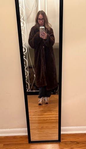 Reviewer taking a mirror selfie in the brown Lucie Faux Fur Maxi Coat, showing its long, oversized fit.