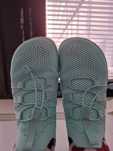 Asiakkaan mintunvihreät Vaistoa Riemu -paljasjalkakengät jalassa sisätiloissa.