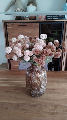 Recensent toont het boeket Zijden Kiku Bloemen in een grote, decoratieve vaas op tafel.