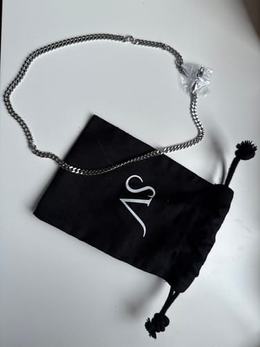 Foto de un cliente de la Cadena Miami Cuban de 5 mm sobre una superficie blanca, junto a su bolsa negra de empaque.
