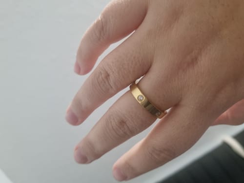 Nahaufnahme der Hand eines Kunden, der den vergoldeten Arianna Ring mit Zirkonia-Steinen trägt.