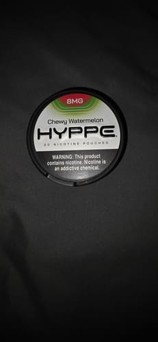 Customer's black can of Hyppe Chewy Watermelon 8MG nicotine pouches shown on a dark surface.