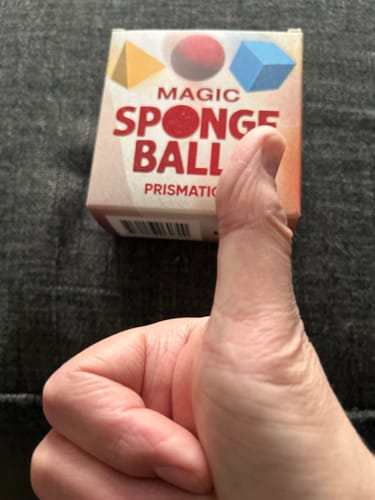 Reviewer's hand gives a thumbs-up in front of the Prismatica Sponge Mystery packaging.