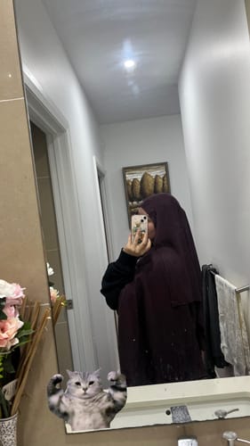 Reviewer in a mirror selfie wearing the Fig Premium Modal hijab, showing its full coverage and deep color.