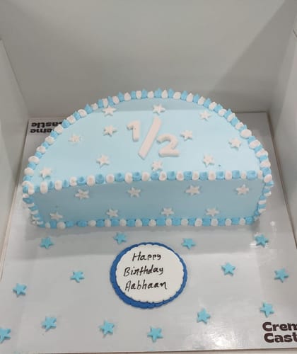 Customer's customized blue Halfway there Cake in its box, decorated with stars, '1/2' on top, and a birthday message.