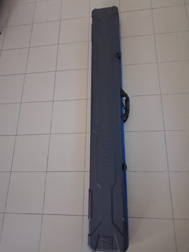 Recensent toont de lange Hardcase Pole Safe XL op een tegelvloer.