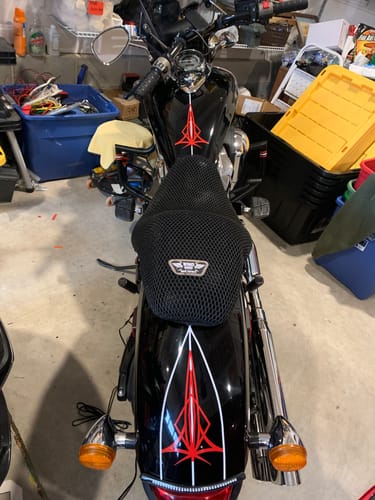 Customer's black mesh Wind Rider Seat Cover installed on a black motorcycle, shown from the rear in a garage.