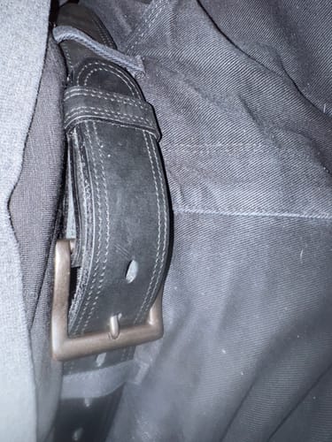 Close-up of a customer wearing the Distressed Black #1 Buckle on a black belt.