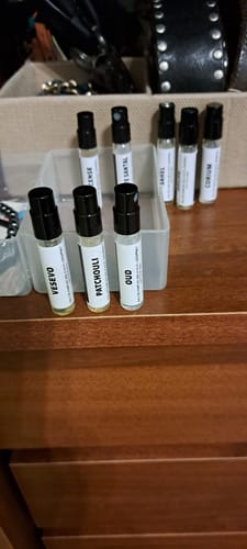 Recensore mostra i campioni del set orientale e legnoso, con i flaconi di Vesevo, Patchouli e Oud in primo piano.