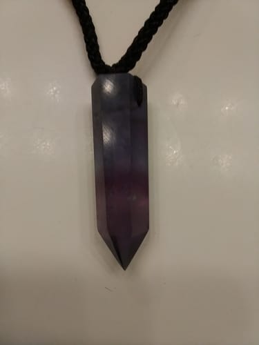 Close-up of a reviewer's Natural Fluorite Necklace, showing the dark purple crystal pendant.