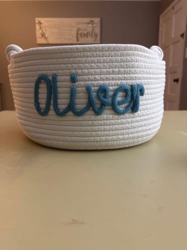 Customer's white Personalized Knitted Basket with the name 'Oliver' in blue knitted yarn.