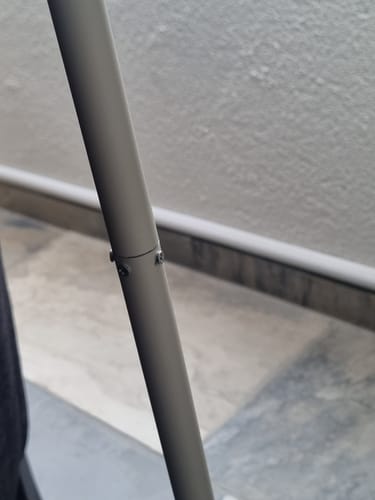 Recensent toont een close-up van de standaard van de Bloop vloerlamp, die gerepareerd is met drie schroeven.