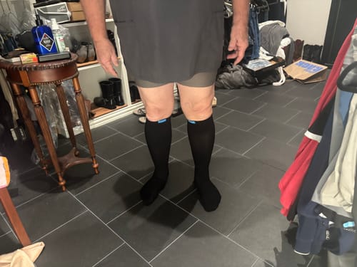 Reviewer wearing black Performance Eucalyptus Compression Socks, showing the front view while standing indoors.
