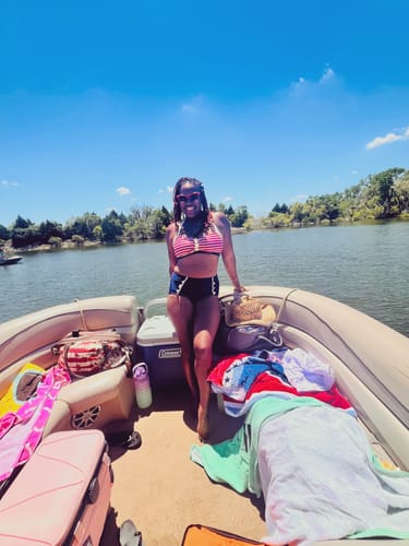 Reviewer standing on a boat wearing the Navy Red 1950s Stripe Halter Bikini.