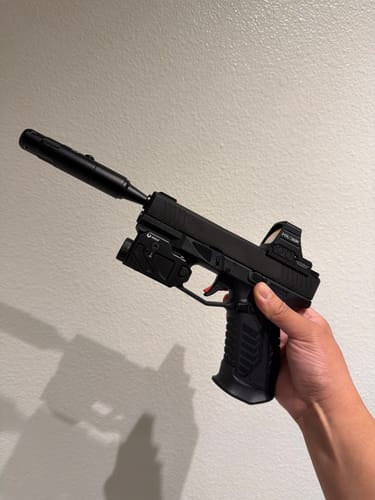 Customer holding a black handgun with the Site Right™ 2.0 - Boresighter inserted into the barrel, aligning an attached optic.