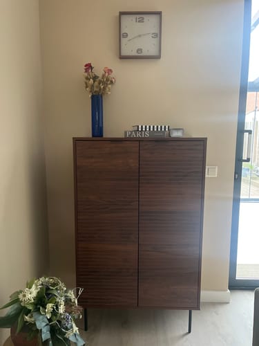 Klant toont de stijlvolle by fonQ Tier Opbergkast in een woonkamer, met een vaas erop.