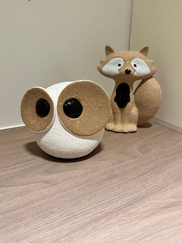 Customer's Big Eyed Owl ceramic figurine on a wooden surface, with a fox figurine visible in the background.