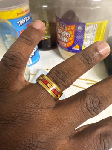 Customer shows a close-up of their gold Fyren ring, highlighting the red inlay.