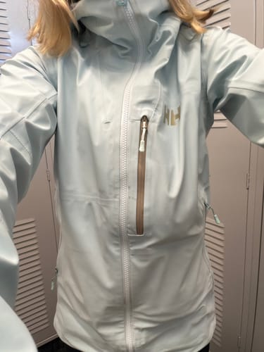 Reviewer wearing the light blue Helly Hansen Verglas Ski Jacket, fully zipped with the hood up.
