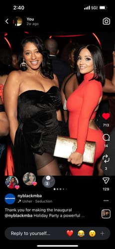 Reviewer in a red Leona Dress with an open back, posing with another person at an event.
